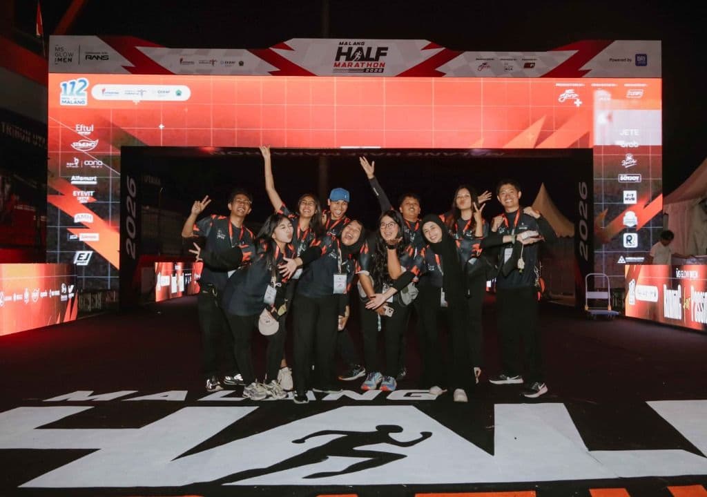 Kru acara berpose di gerbang Malang Half Marathon