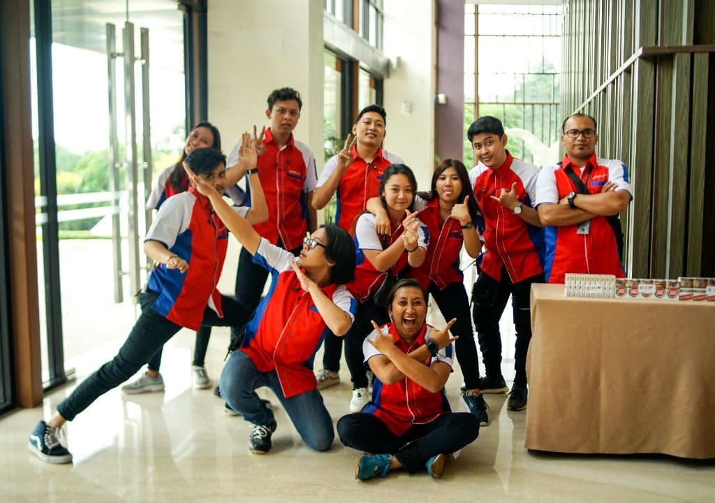 Kru D'Production berpose bersama memakai rompi merah biru
